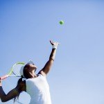 Female tennis player serving confidently
